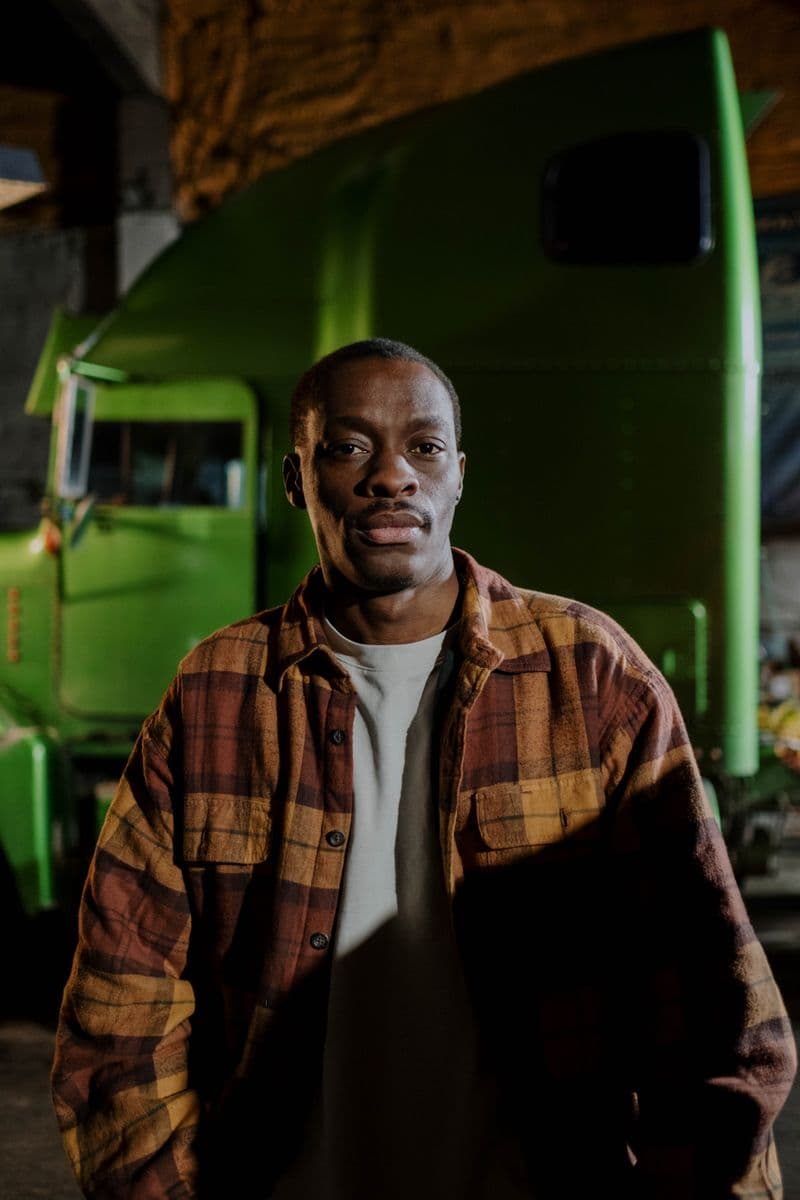 Owner-operator in a flannel shirt beside his rig