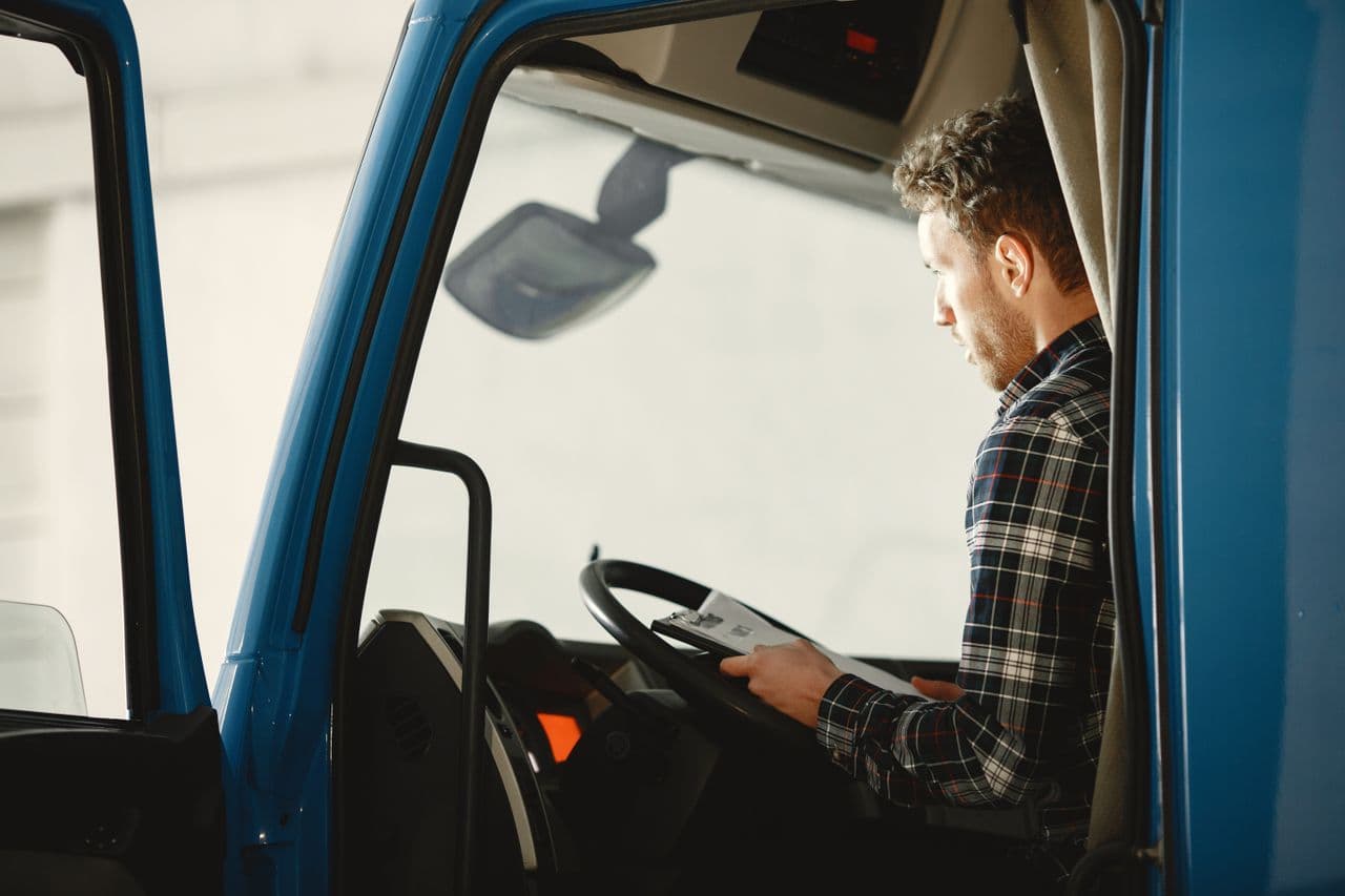 Truck driver reviewing paperwork in the cab before a haul